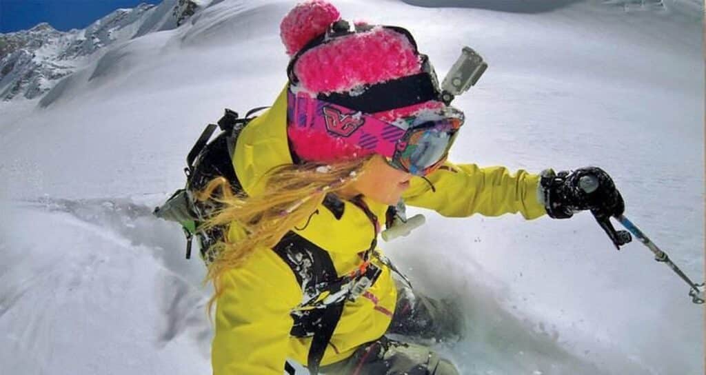 Vrouw skiet door poedersneeuw in bergen