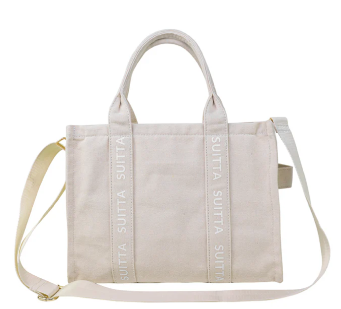 Beige canvas tote met schouderriem en handvatten.