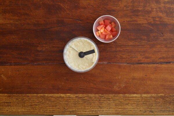 Kom met gehakt tomaten en puree op houten tafel.