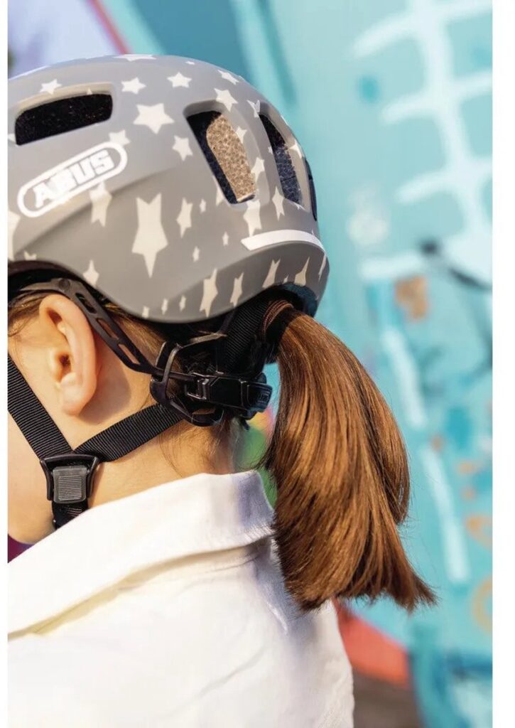 Child wearing a gray helmet with a star print