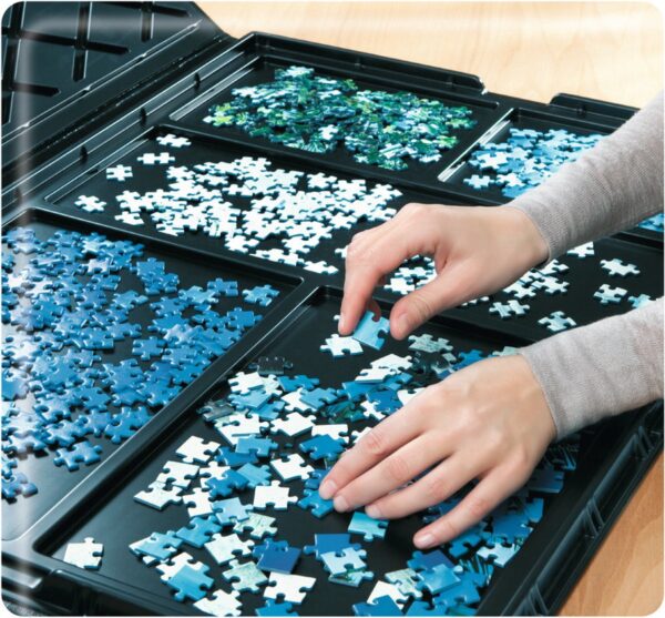 Handen sorteren puzzelstukjes in vakken