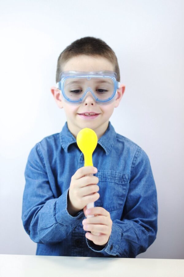 Kind met veiligheidsbril en gele ballon