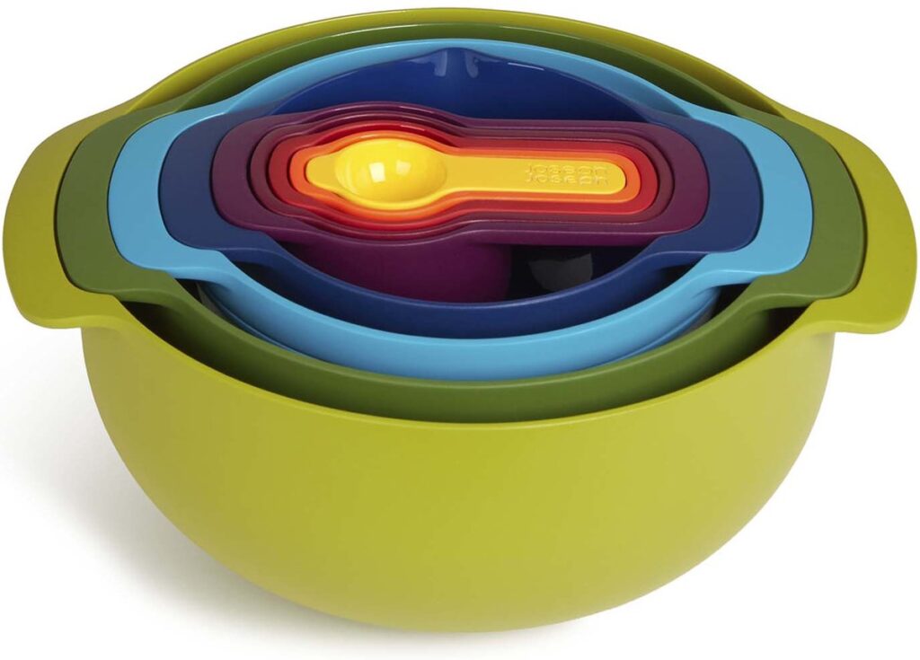 Colored measuring cups in a green bowl