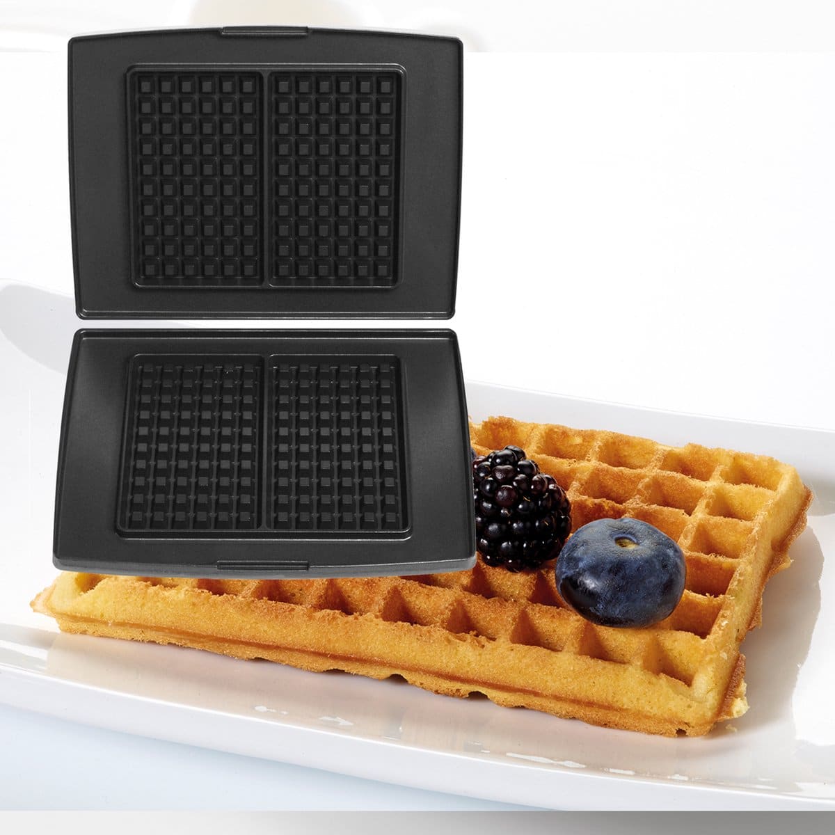 Wafelijzer met versgebakken wafel en bessen