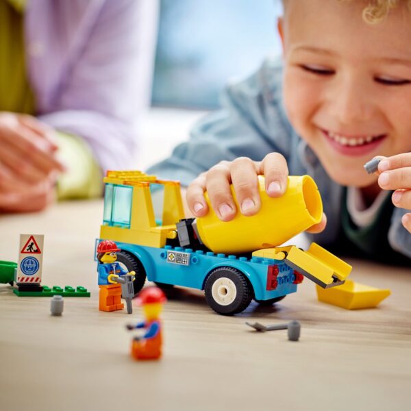 Kind speelt met speelgoedcementmixer en LEGO-figuurtjes.