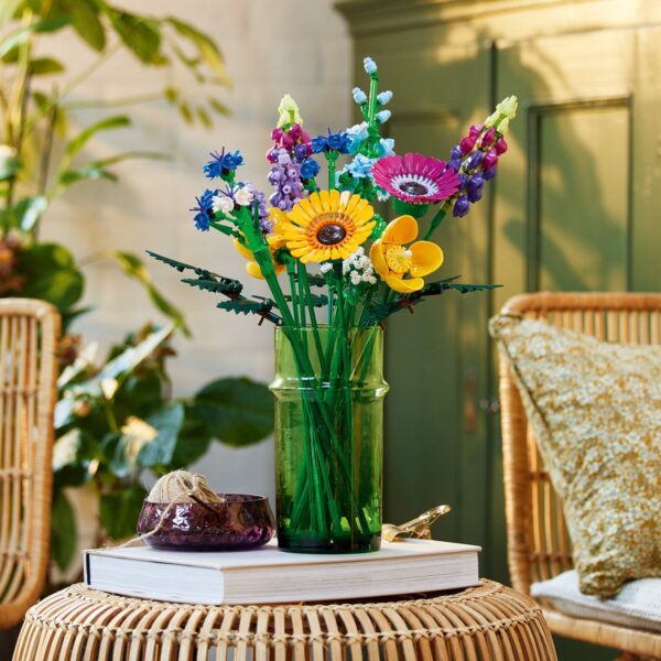 Vaas met kleurrijke bloemen op tafel in kamer.