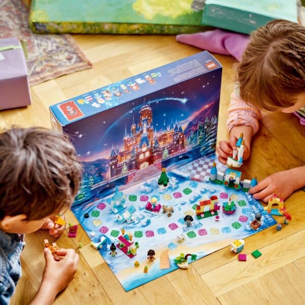 Kinderen spelen met Lego-kerstset op houten vloer.