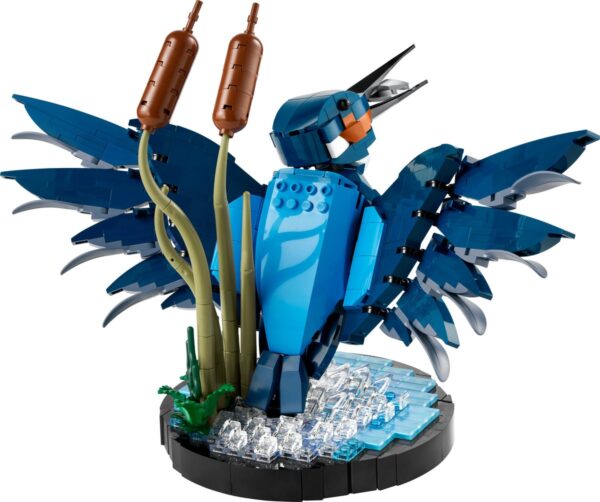 Blauwe LEGO vogel naast riet en water.