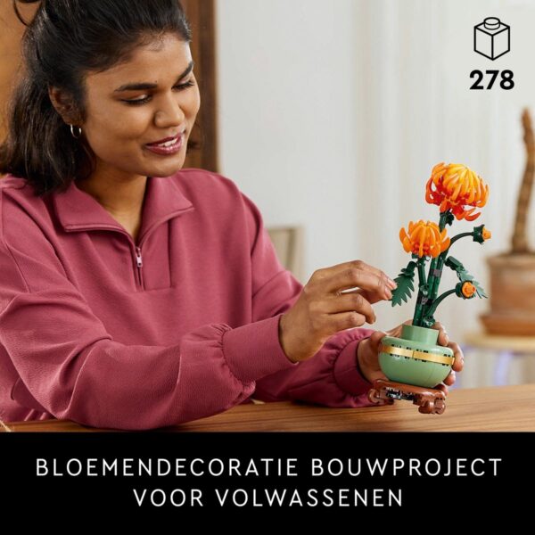 Vrouw bouwt bloemenproject met LEGO-stenen.