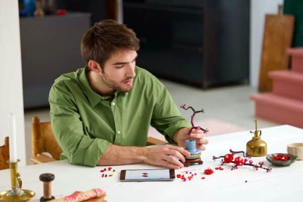 Man bouwt miniatuur boom op tafel met tabletscherm.