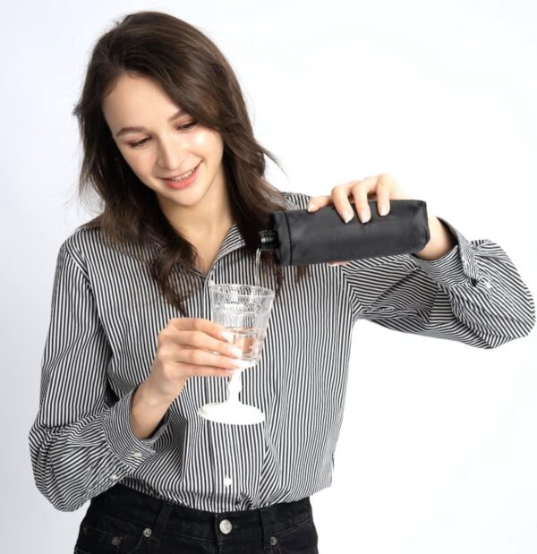 Vrouw schenkt drankje in glas.