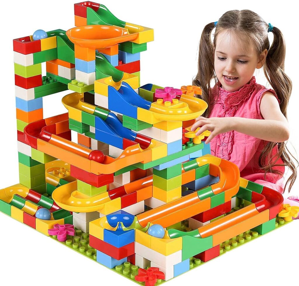 Kind speelt met kleurrijke bouwblokken en knikkerbaan