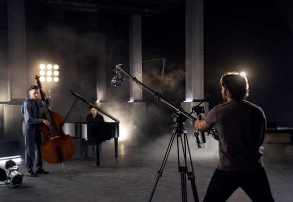 Filmmaker neemt muzikanten op in een donkere studio.