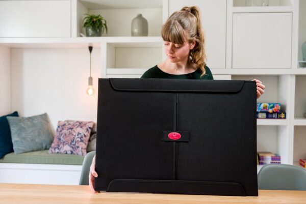 Vrouw met grote zwarte draagtas thuis