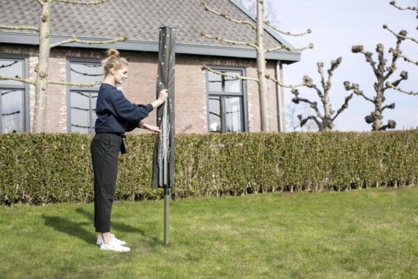 Vrouw opent beschermhoes voor tuinparasol.