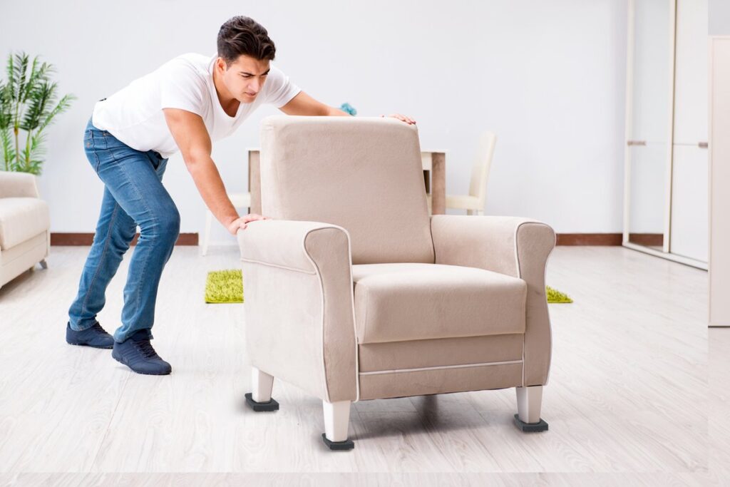 Man duwt beige stoel in woonkamer