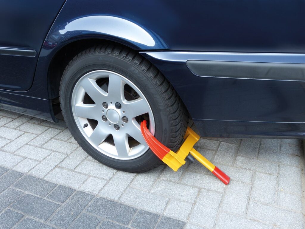 Wielklem op geparkeerde auto op straat