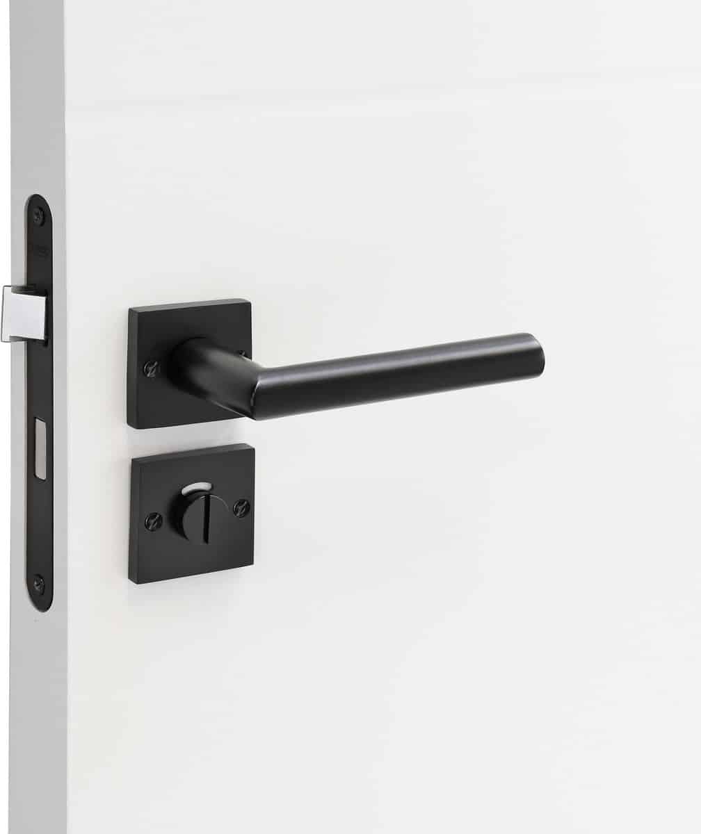 Zwarte deurklink en slot op witte deur