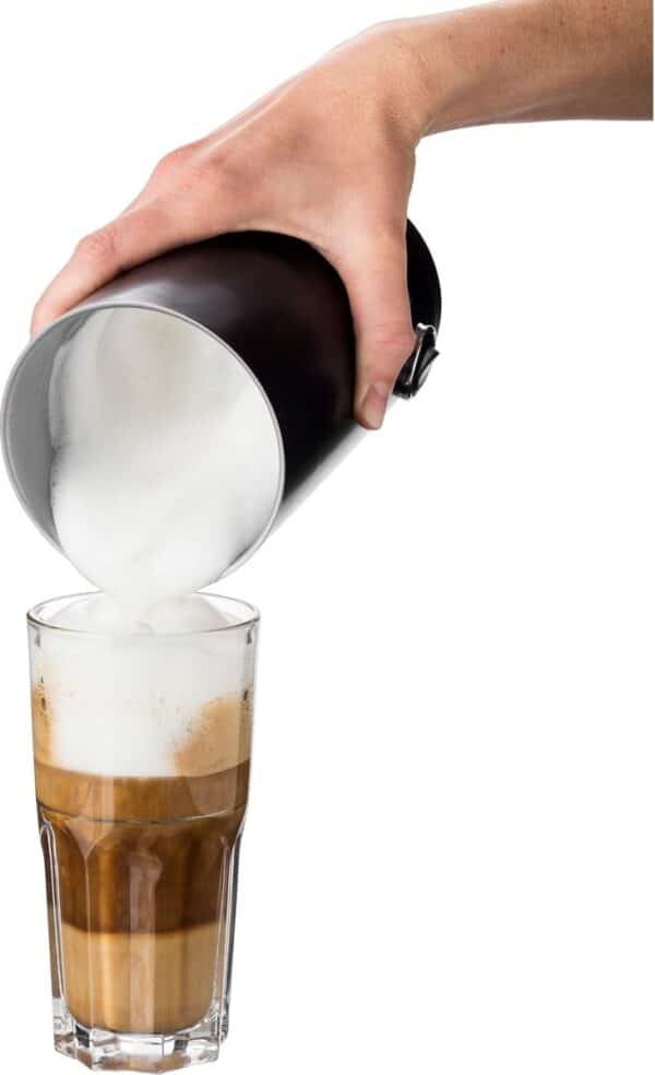 Melkschuim wordt in koffieglas gegoten