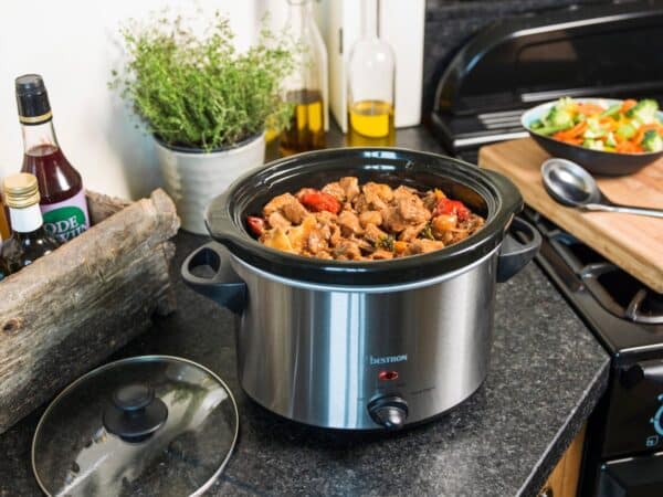 Slowcooker met stoofpot op aanrecht in keuken.