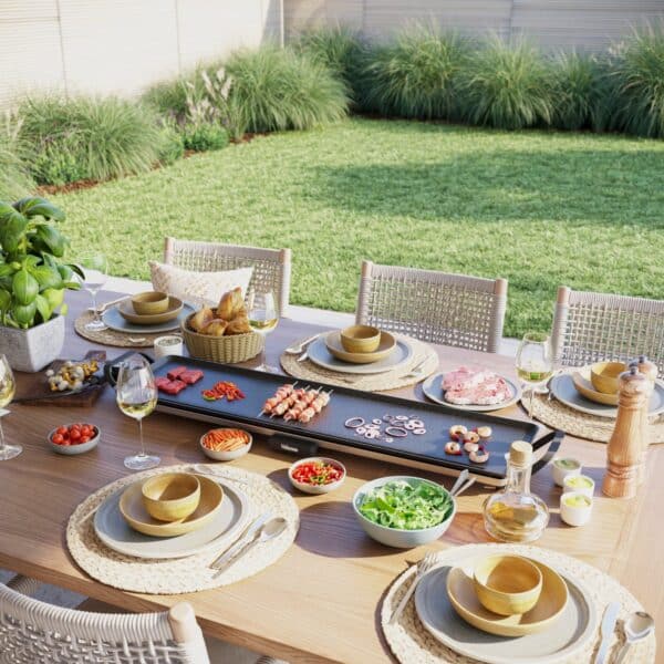 Gezellig gedekte tuintafel met barbecue en gerechten.