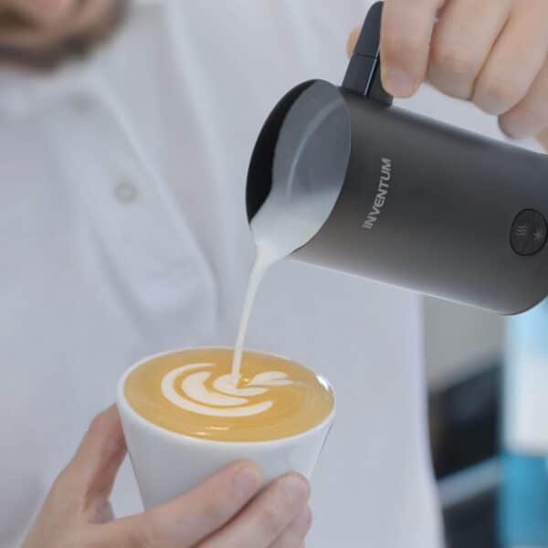 Schuim wordt in koffie gegoten voor latte art.