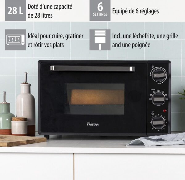 Zwarte oven met instellingen en accessoires op aanrecht