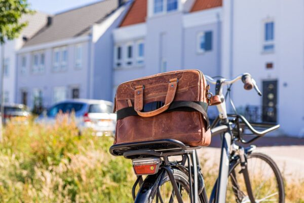 Fiets met bruine tas voor huis