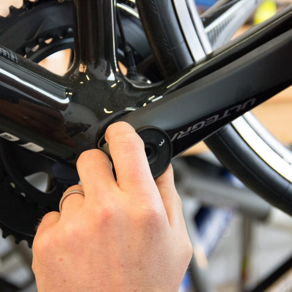 Hand monteert bidonhouder op fietsframe