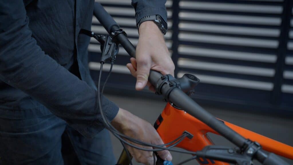 Cyclist adjusts the handlebars of an orange bicycle