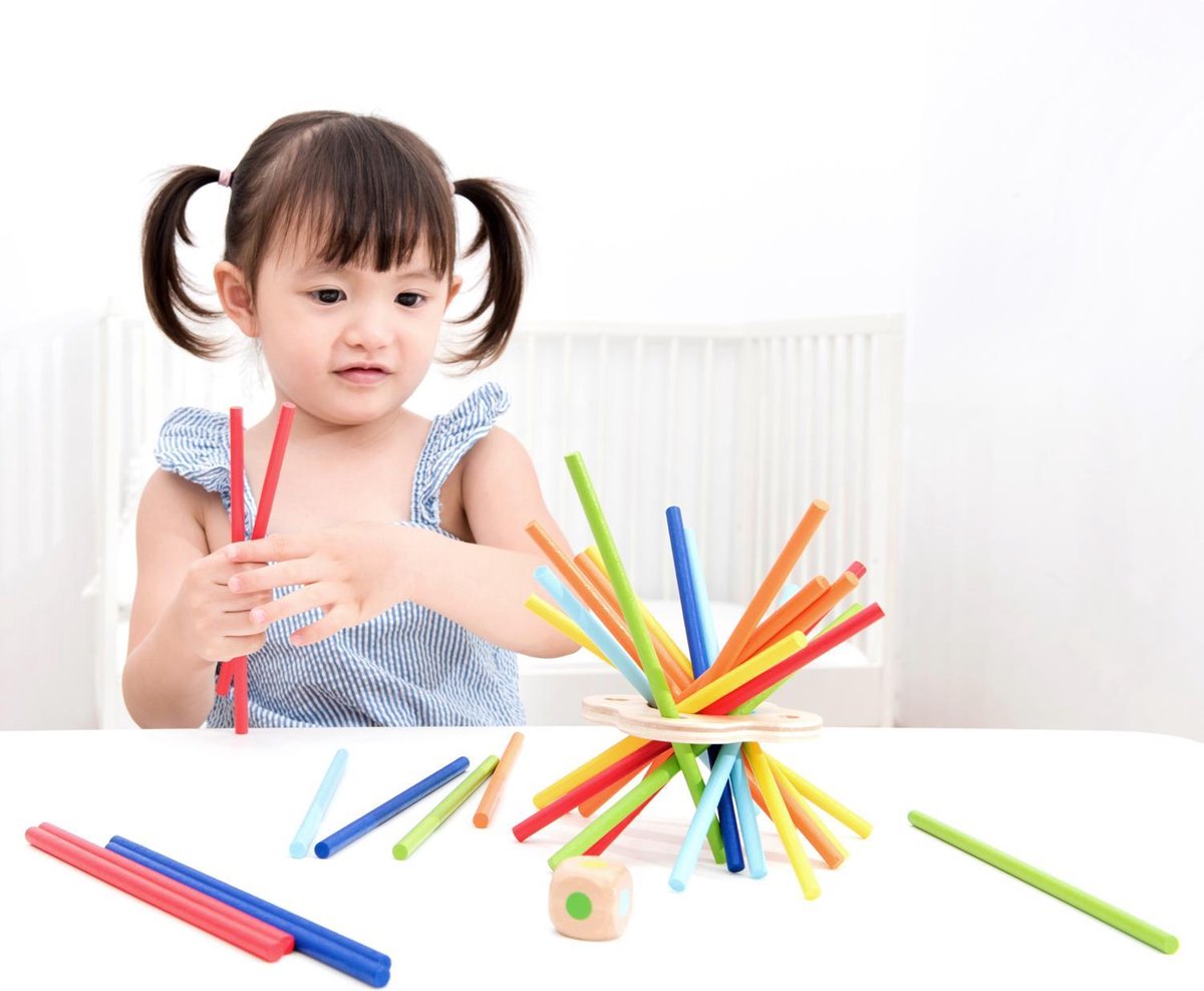 Peuter speelt met kleurrijke stapelstokjes.