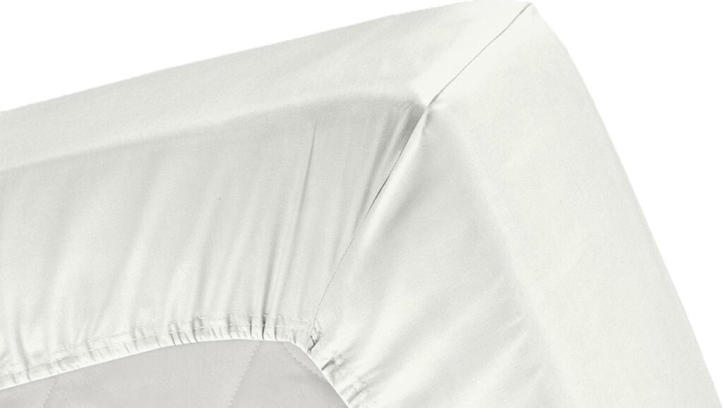 Witte hoek van opgemaakt bed met hoeslaken