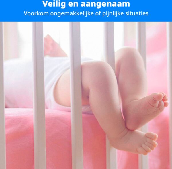 Kindervoeten in veilige wieg met roze beddengoed.