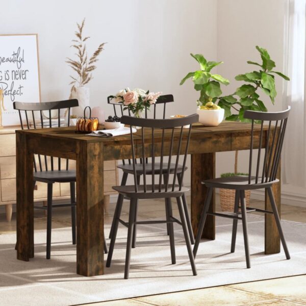 Eettafel met stoelen en planten in zonnige kamer.