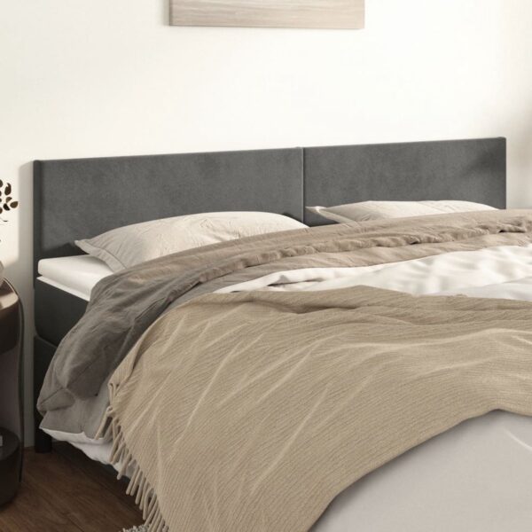 Grijs bedframe met beige dekens en kussens.