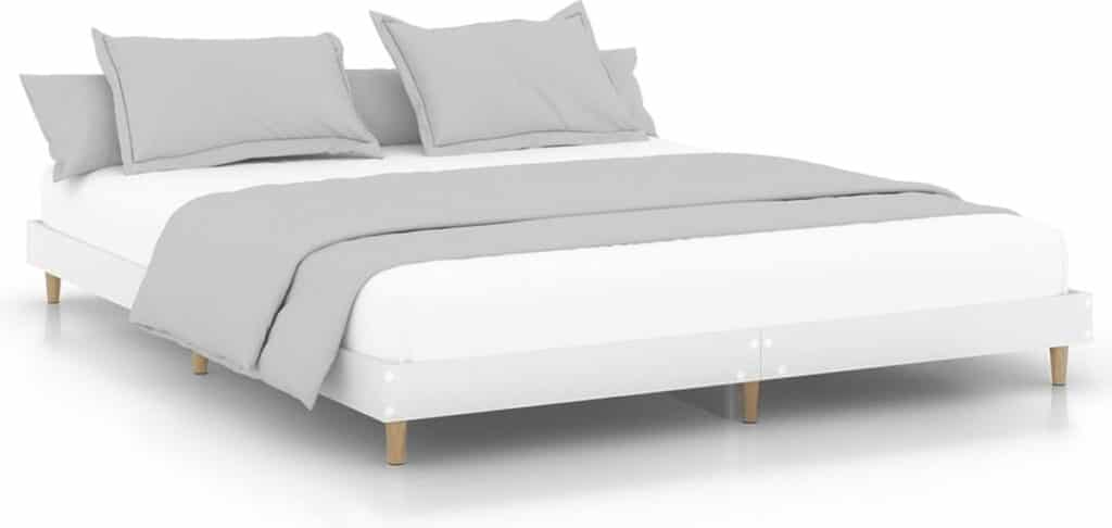 Modern wit bed met grijze dekens en kussens