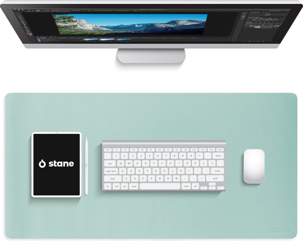 Bureaublad met computer, toetsenbord en tablet.