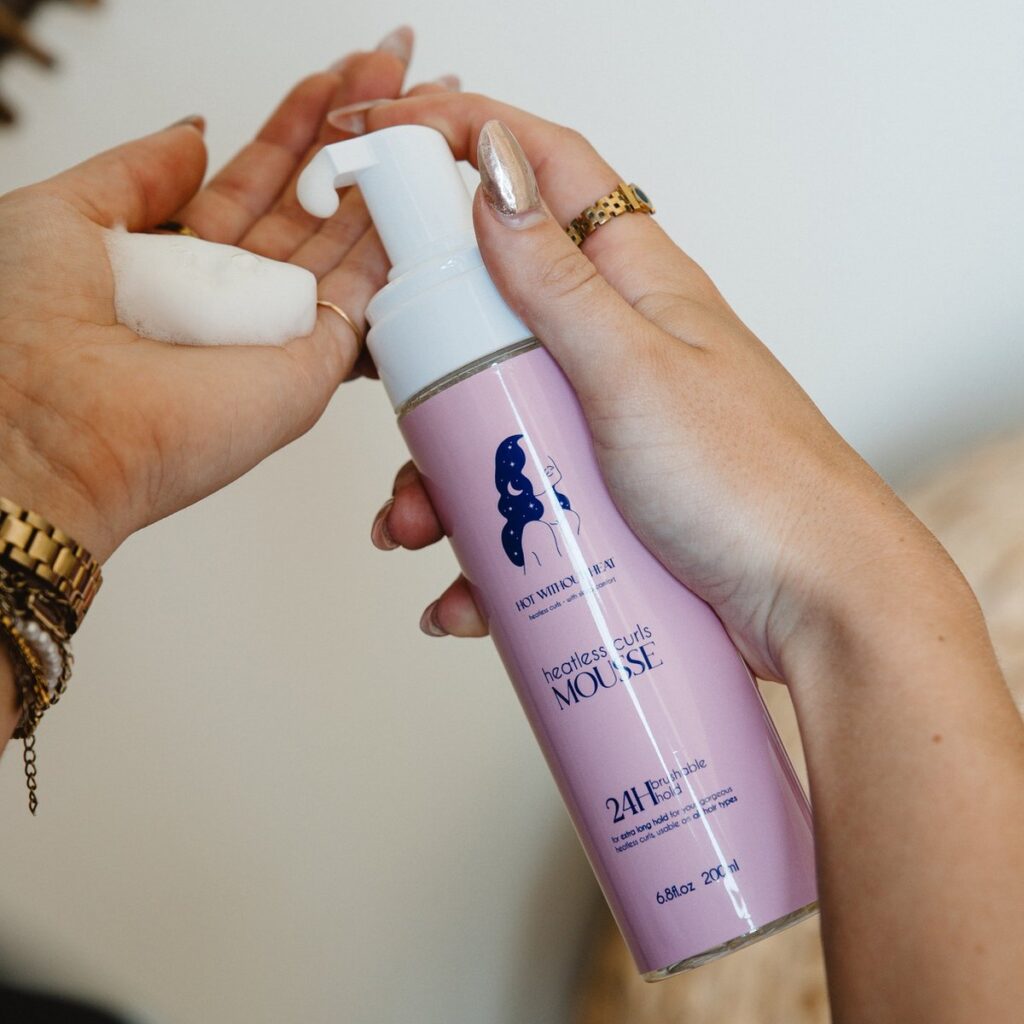 Handen houden haarschuimfles