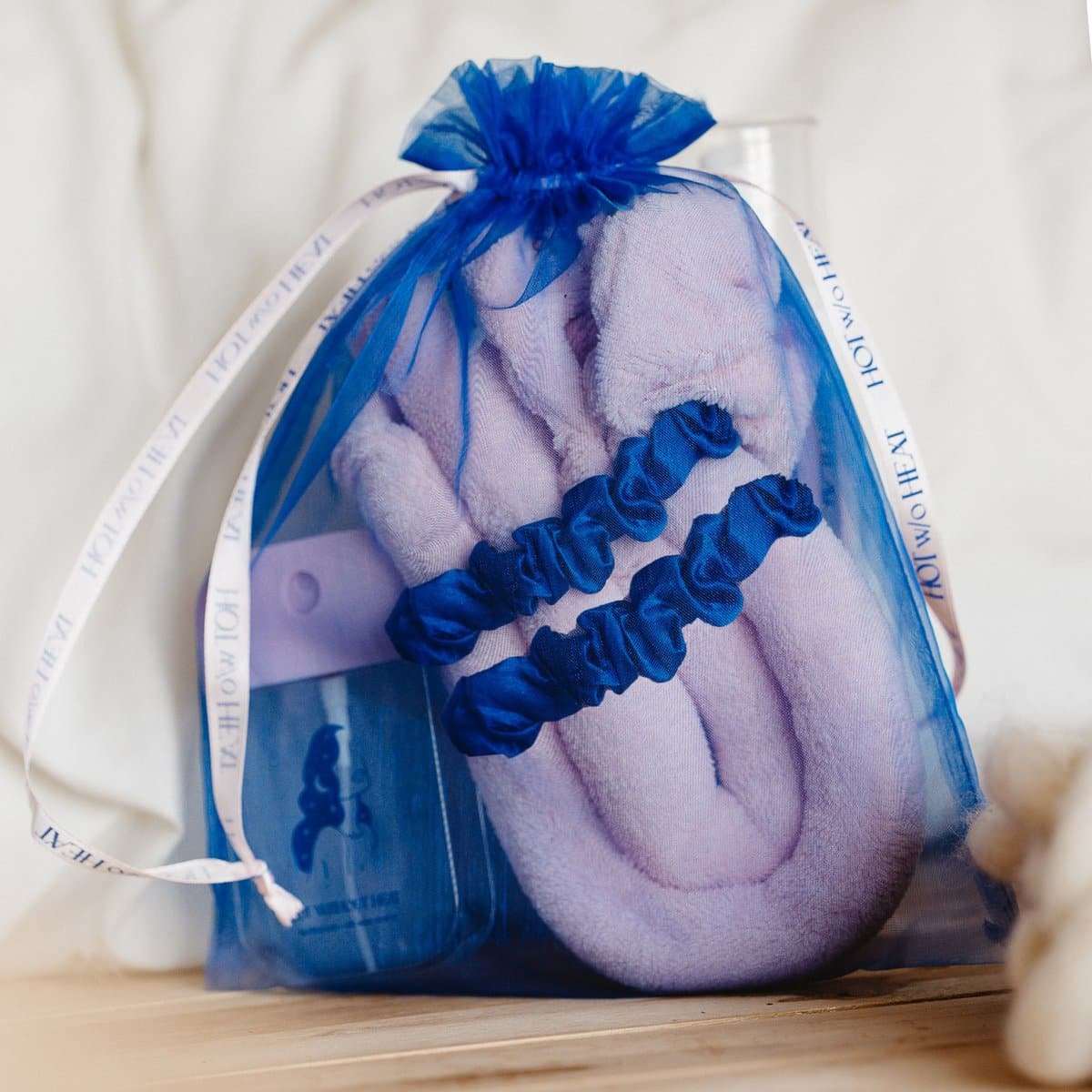 Blauwe geschenkzak met paarse haarproducten.